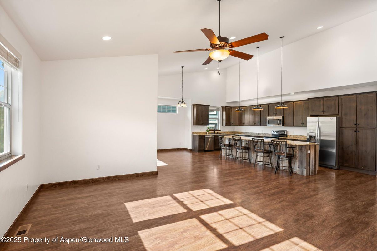 Empty room, Interior, Kitchen, Pendant Lights, Recessed Lighting, Stainless Steel Appliances, Wood Texture Flooring