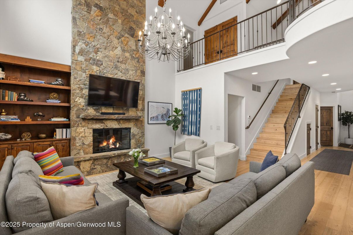 Chandelier, Fireplace, Interior, Living room, Recessed Lighting, Stone Walls, Wood Texture Flooring