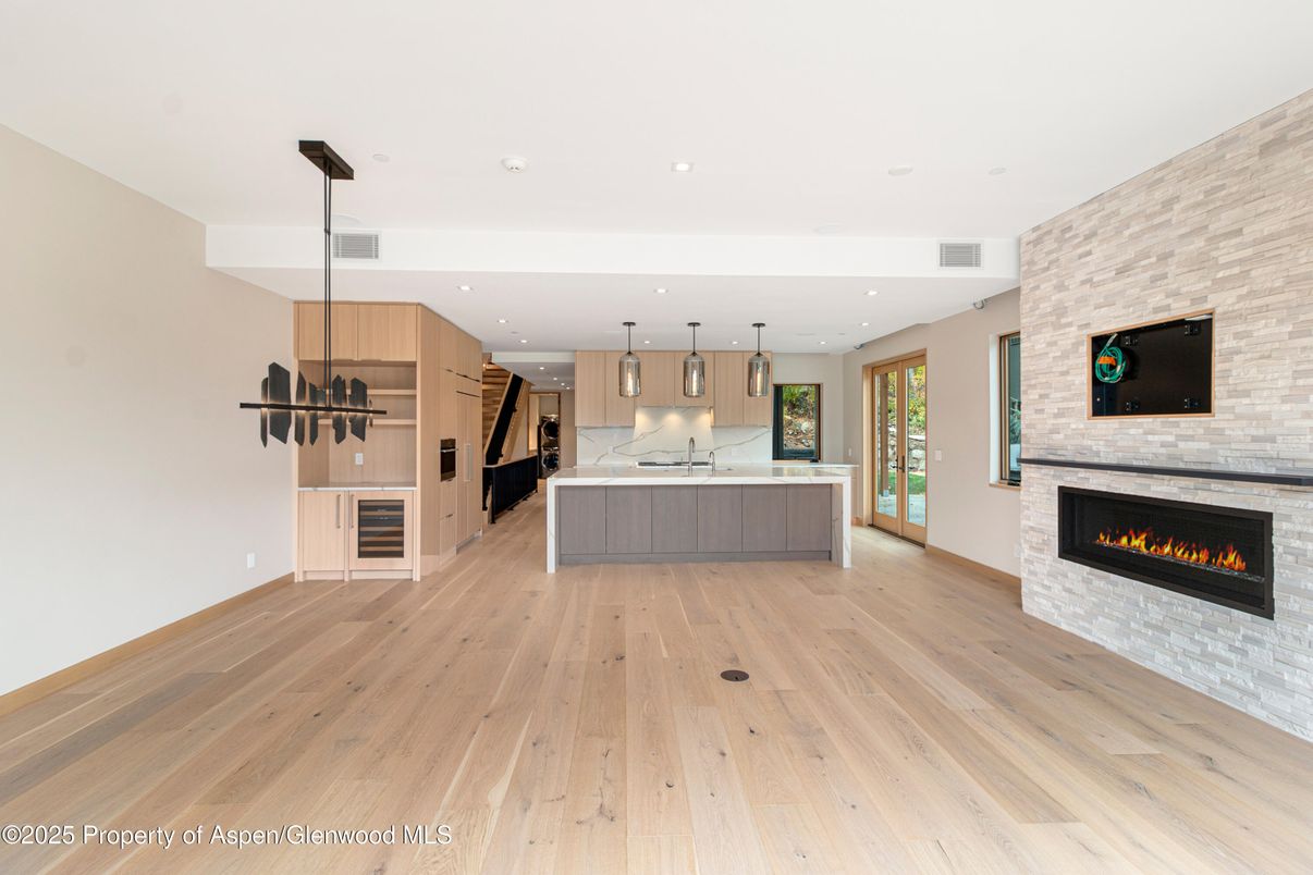 Fireplace, Interior, Kitchen, Pendant Lights, Recessed Lighting, Stainless Steel Appliances, Stone Walls, Wood Texture Flooring