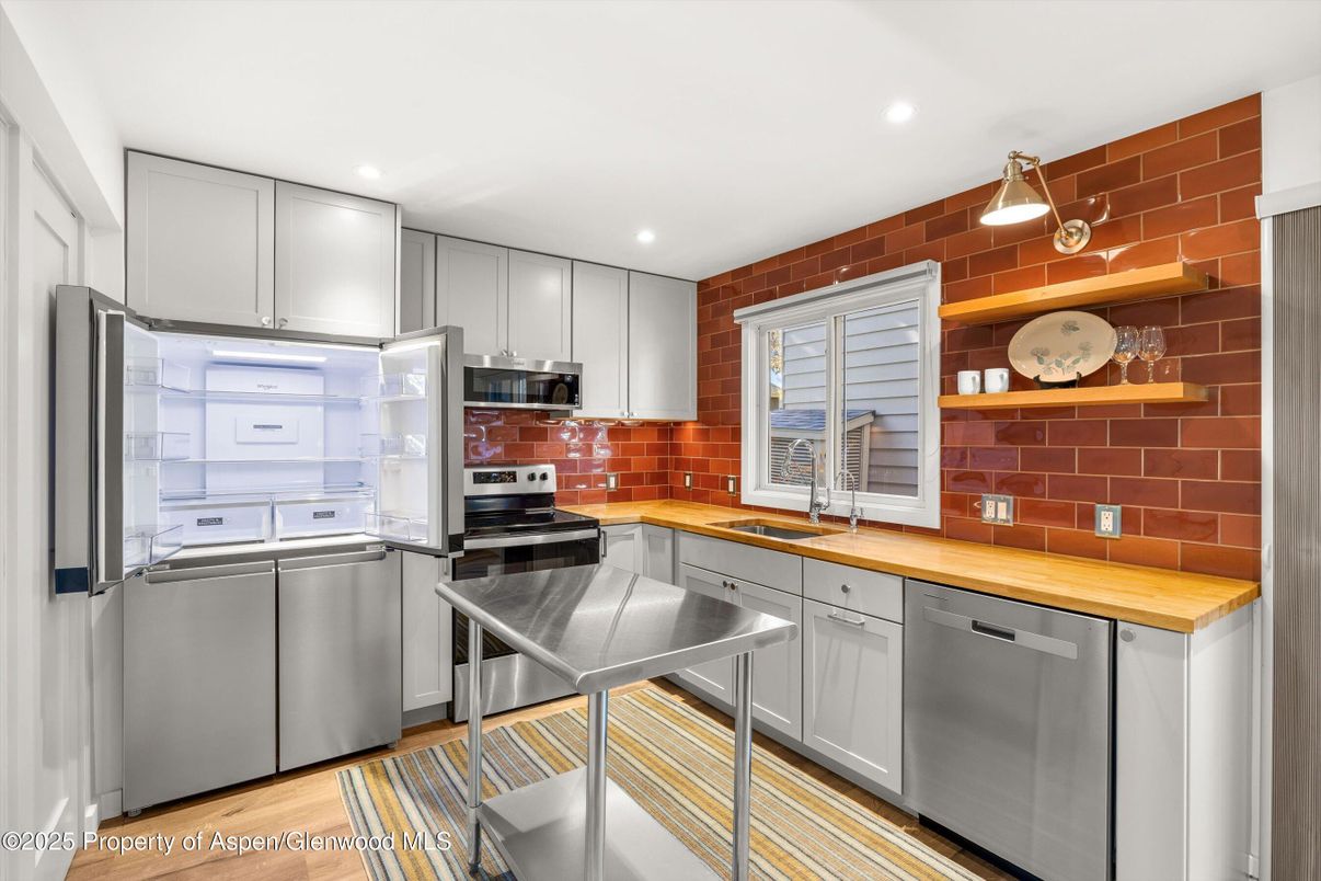 Interior, Kitchen, Recessed Lighting, Stainless Steel Appliances, Stone Walls, Washer, Wood Texture Flooring