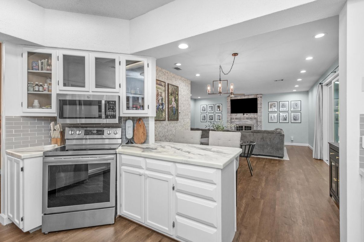 Fireplace, Interior, Kitchen, Pendant Lights, Recessed Lighting, Stainless Steel Appliances, Stone Walls, Wood Texture Flooring