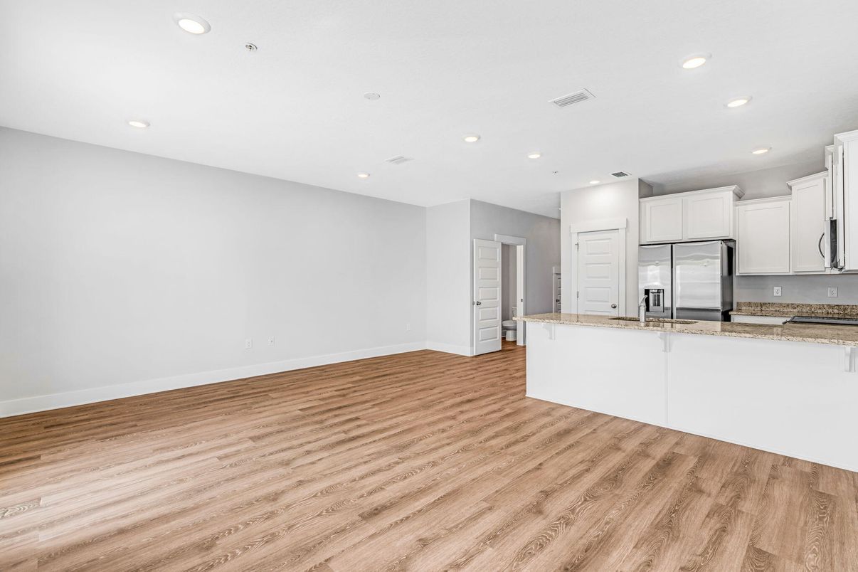 Empty room, Interior, Kitchen, Recessed Lighting, Stainless Steel Appliances, Wood Texture Flooring