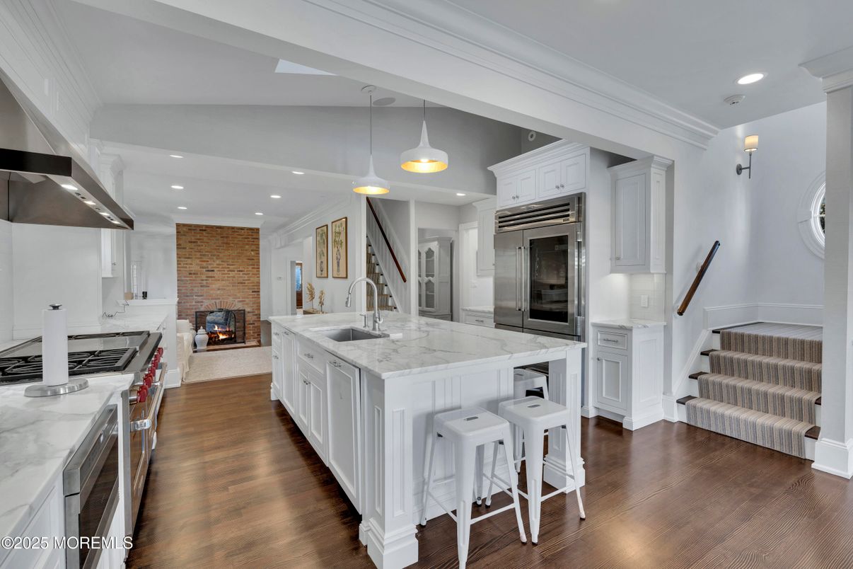 Fireplace, Interior, Kitchen, Pendant Lights, Recessed Lighting, Stainless Steel Appliances, Stone Walls, Wood Texture Flooring