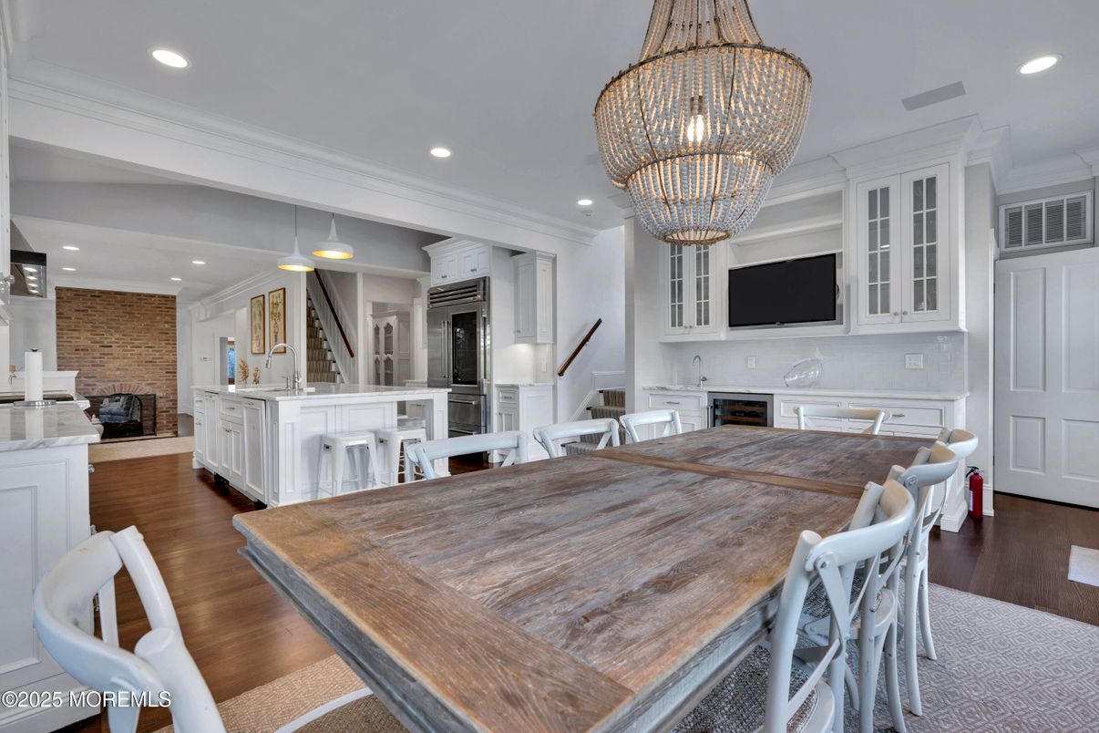 Chandelier, Dining room, Fireplace, Interior, Kitchen, Pendant Lights, Recessed Lighting, Stainless Steel Appliances, Stone Walls, Wood Texture Flooring