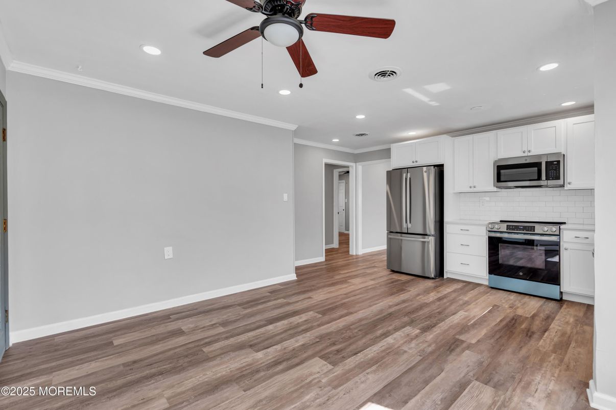 Empty room, Interior, Kitchen, Recessed Lighting, Stainless Steel Appliances, Wood Texture Flooring