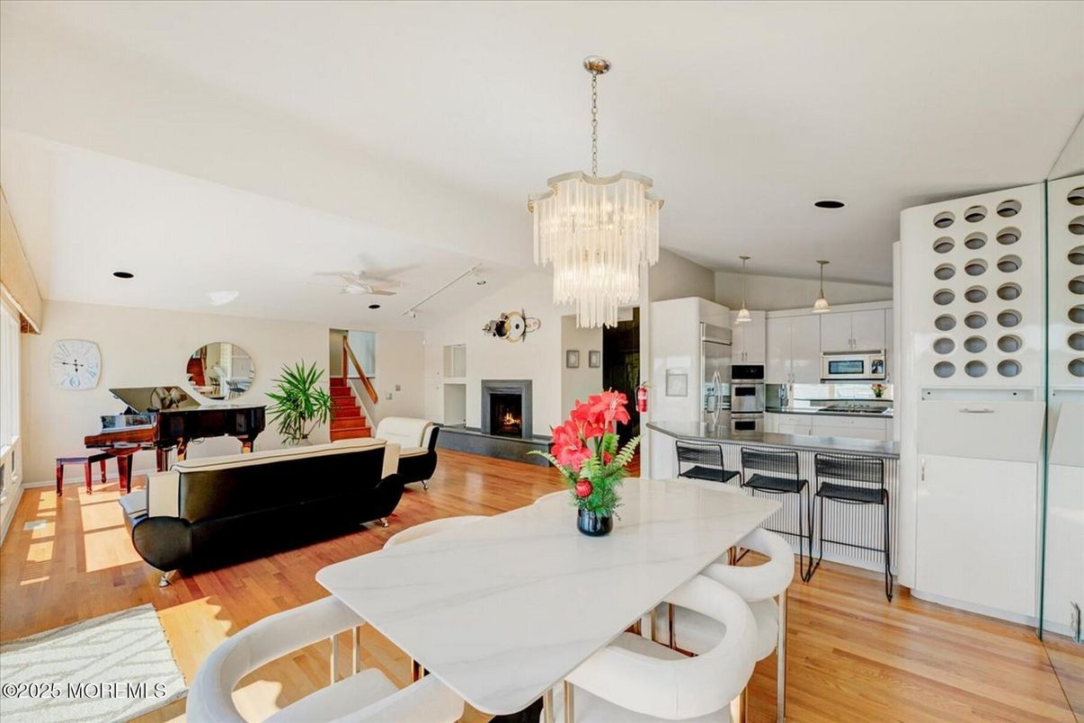 Chandelier, Dining room, Fireplace, Interior, Kitchen, Living room, Pendant Lights, Piano, Stainless Steel Appliances, Wood Texture Flooring