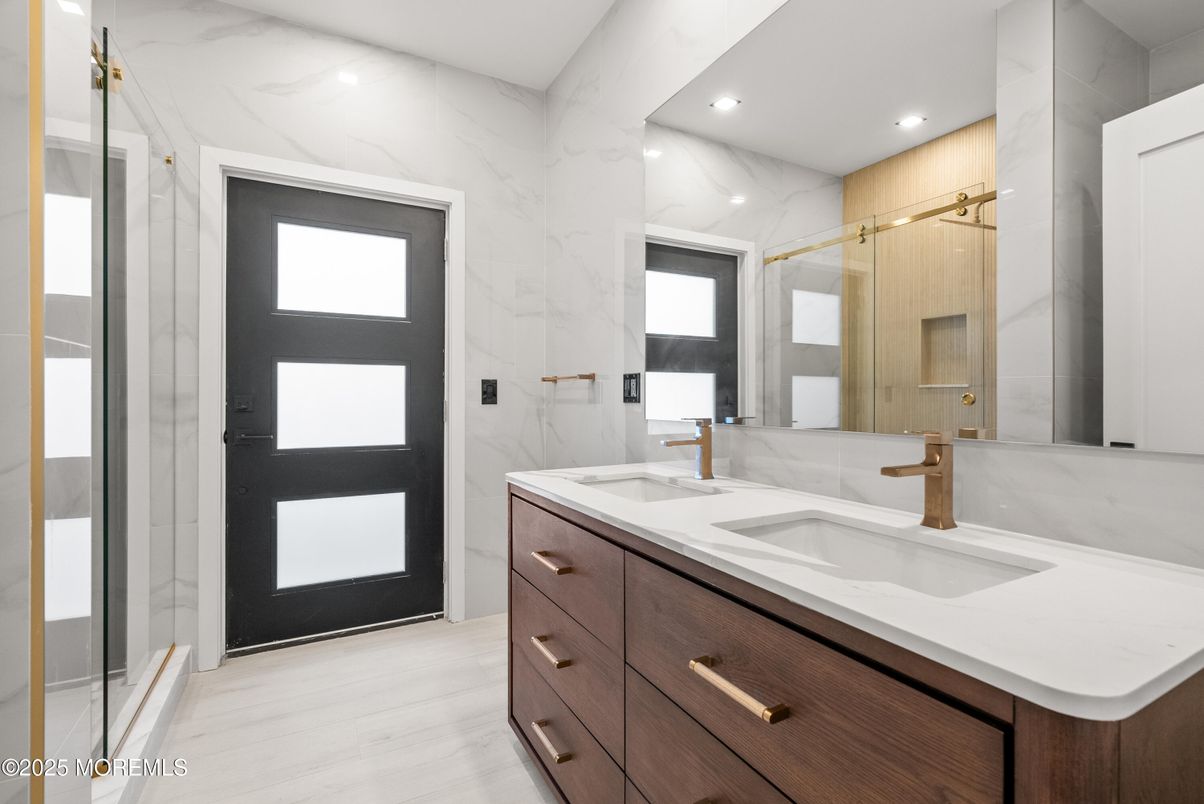 Bathroom, Dual Sink Vanities, Glass Shower, Interior, Marble Walls, Recessed Lighting, Wood Texture Flooring
