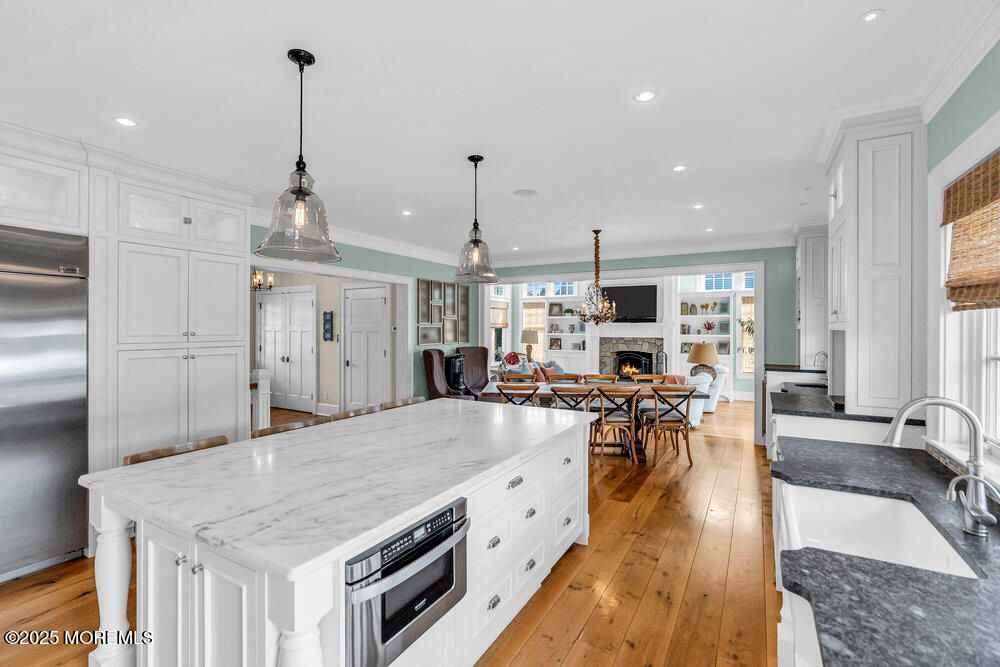 Chandelier, Dining room, Fireplace, Interior, Kitchen, Living room, Pendant Lights, Recessed Lighting, Stainless Steel Appliances, Wood Texture Flooring