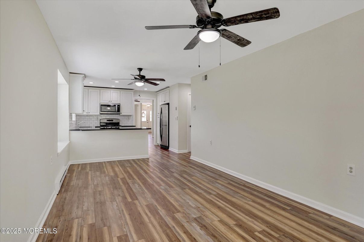 Empty room, Interior, Kitchen, Recessed Lighting, Stainless Steel Appliances, Wood Texture Flooring