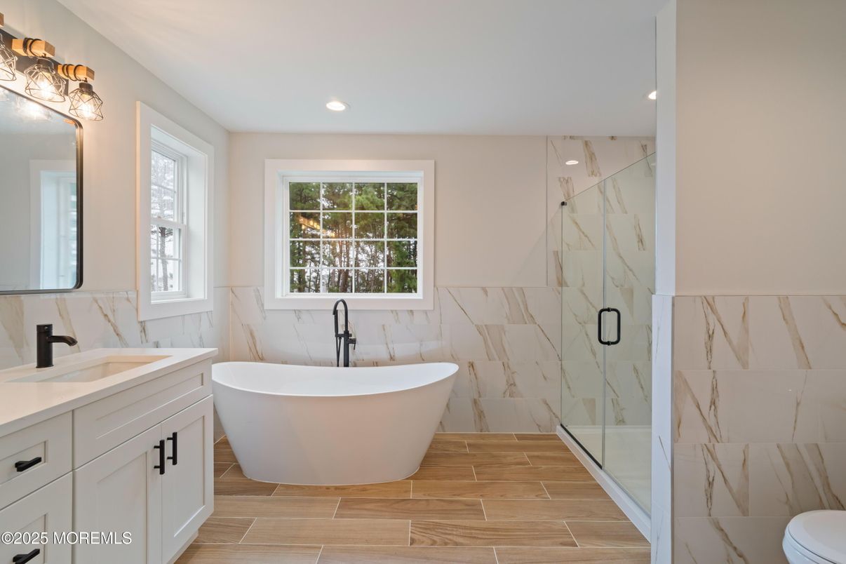 Bathroom, Dual Sink Vanities, Free Standing Baths, Glass Shower, Interior, Marble Walls, Recessed Lighting, Wood Texture Flooring