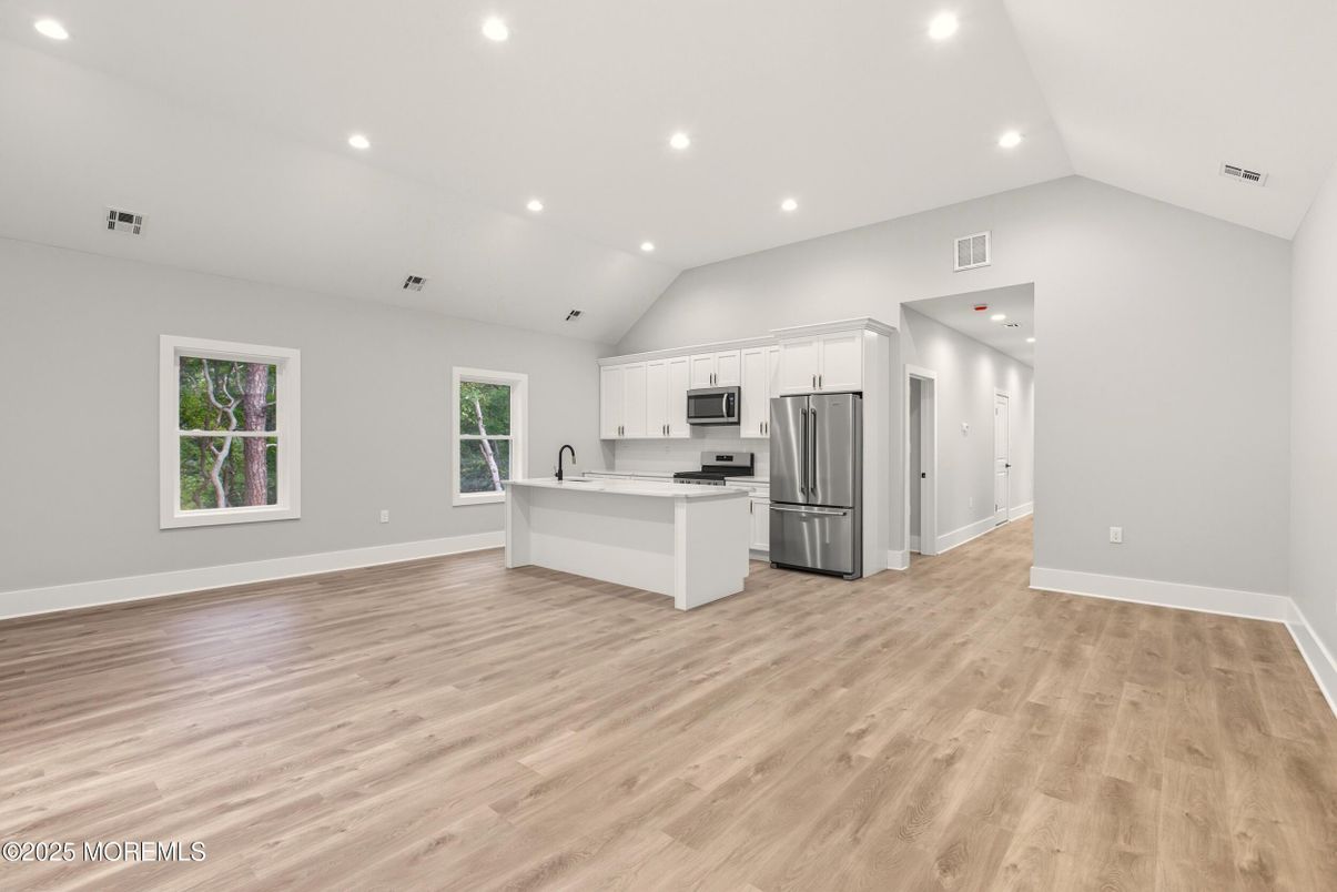 Empty room, Interior, Kitchen, Recessed Lighting, Stainless Steel Appliances, Wood Texture Flooring