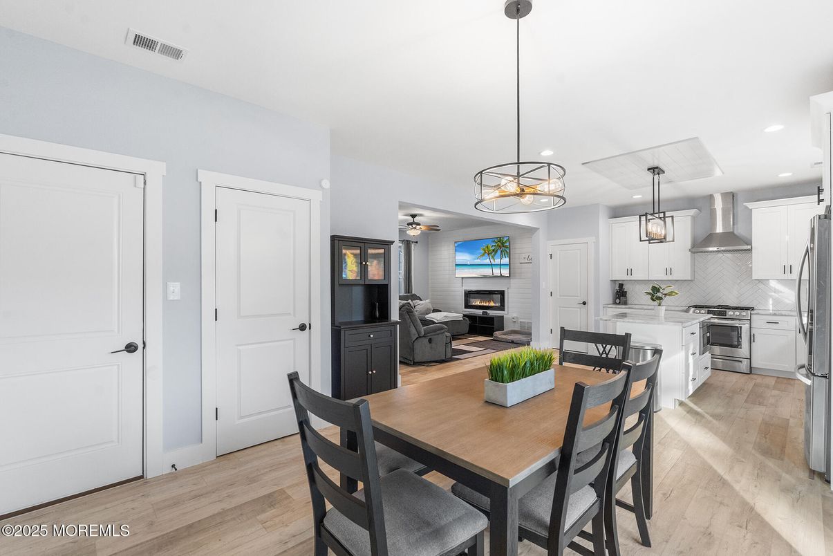 Chandelier, Dining room, Fireplace, Interior, Kitchen, Living room, Pendant Lights, Recessed Lighting, Stainless Steel Appliances, Wood Texture Flooring