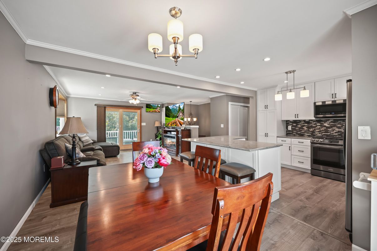 Chandelier, Dining room, Interior, Kitchen, Living room, Pendant Lights, Recessed Lighting, Stainless Steel Appliances, Wood Texture Flooring
