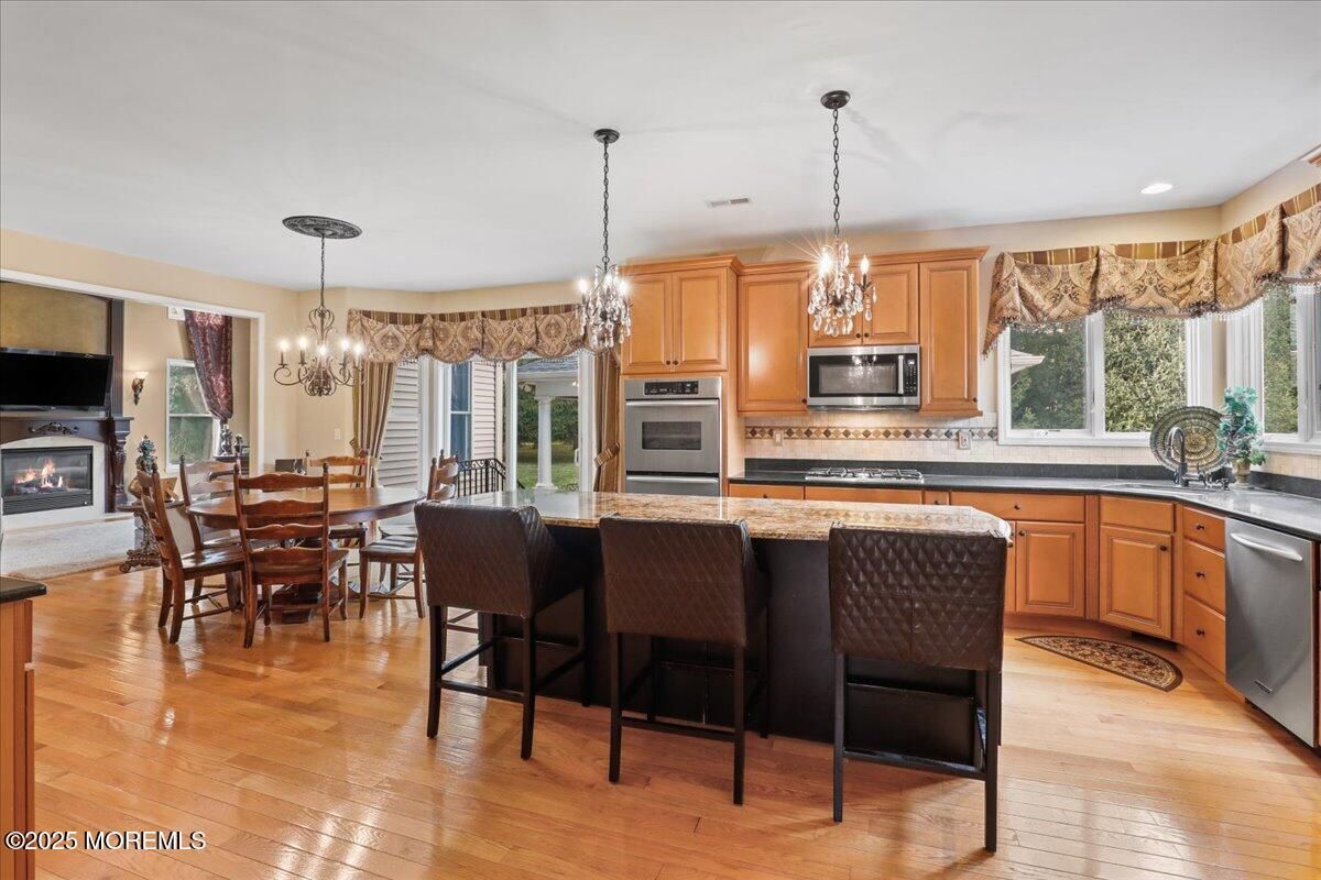 Chandelier, Dining room, Fireplace, Interior, Kitchen, Pendant Lights, Recessed Lighting, Stainless Steel Appliances, Wood Texture Flooring