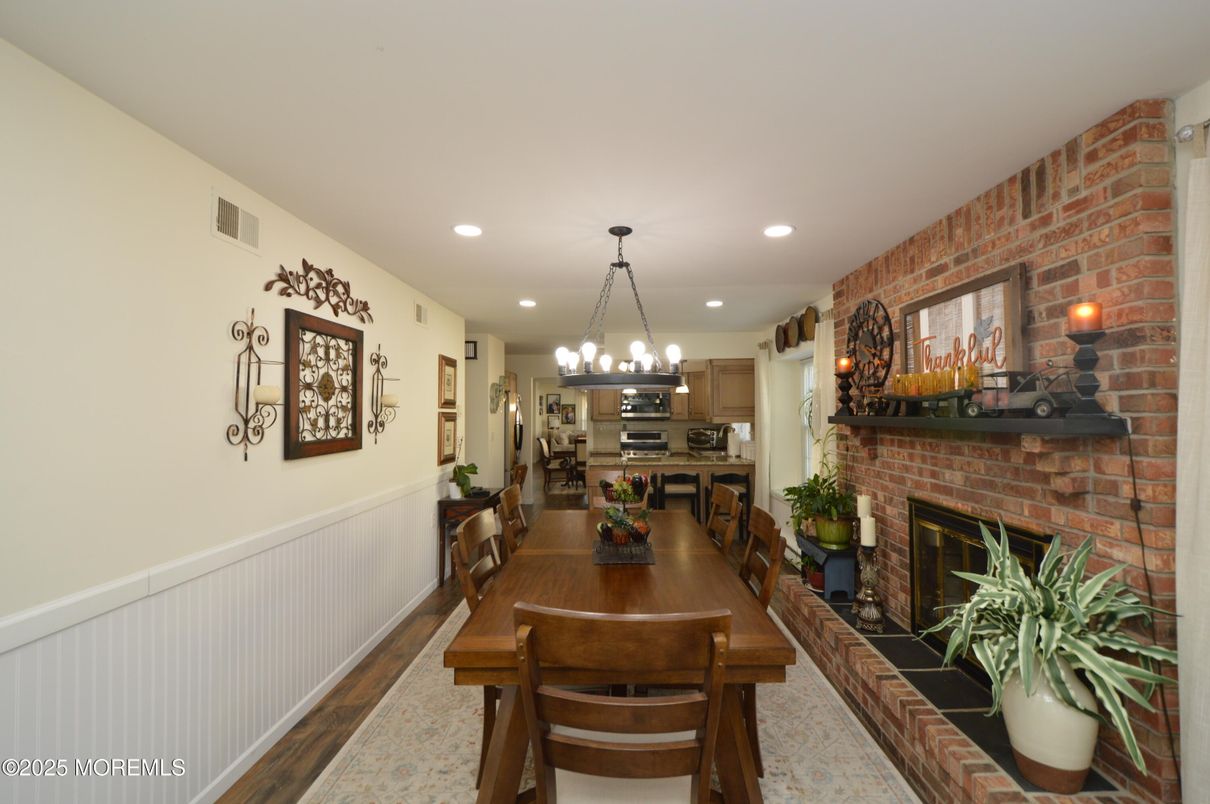 Chandelier, Dining room, Fireplace, Interior, Kitchen, Recessed Lighting, Stainless Steel Appliances, Stone Walls, Wood Texture Flooring