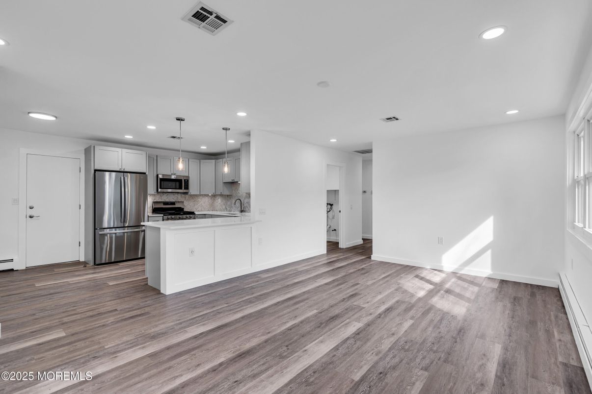 Empty room, Interior, Kitchen, Pendant Lights, Recessed Lighting, Stainless Steel Appliances, Wood Texture Flooring