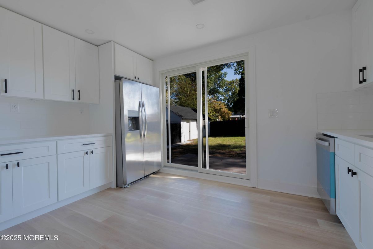Empty room, Interior, Kitchen, Recessed Lighting, Stainless Steel Appliances, Wood Texture Flooring