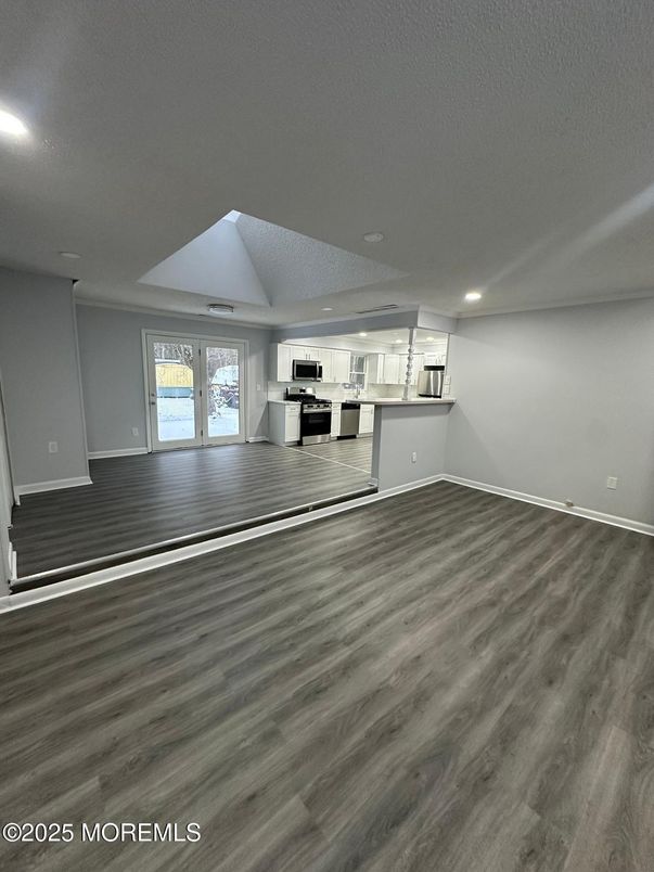Empty room, Interior, Kitchen, Recessed Lighting, Stainless Steel Appliances, Wood Texture Flooring