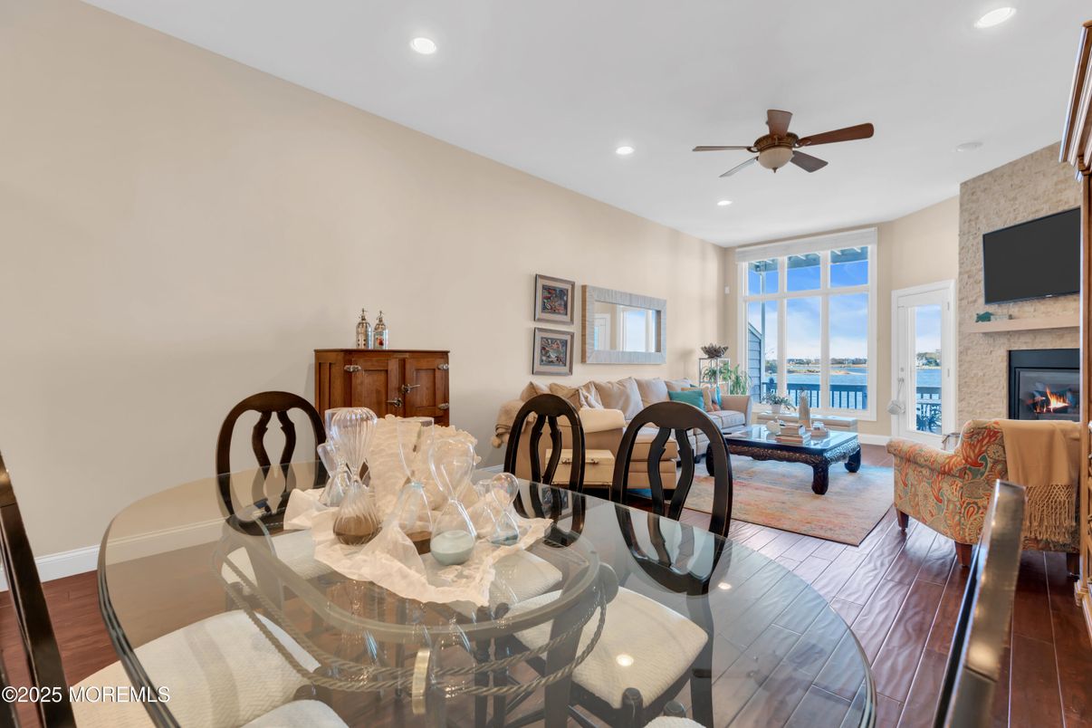 Dining room, Fireplace, Interior, Living room, Recessed Lighting, Stone Walls, Water, Wood Texture Flooring