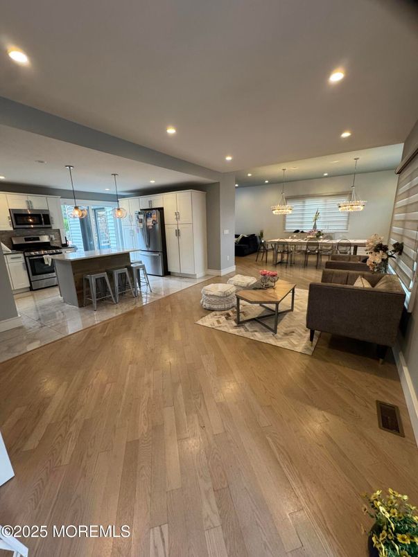 Chandelier, Dining room, Interior, Kitchen, Living room, Pendant Lights, Recessed Lighting, Stainless Steel Appliances, Water, Wood Texture Flooring