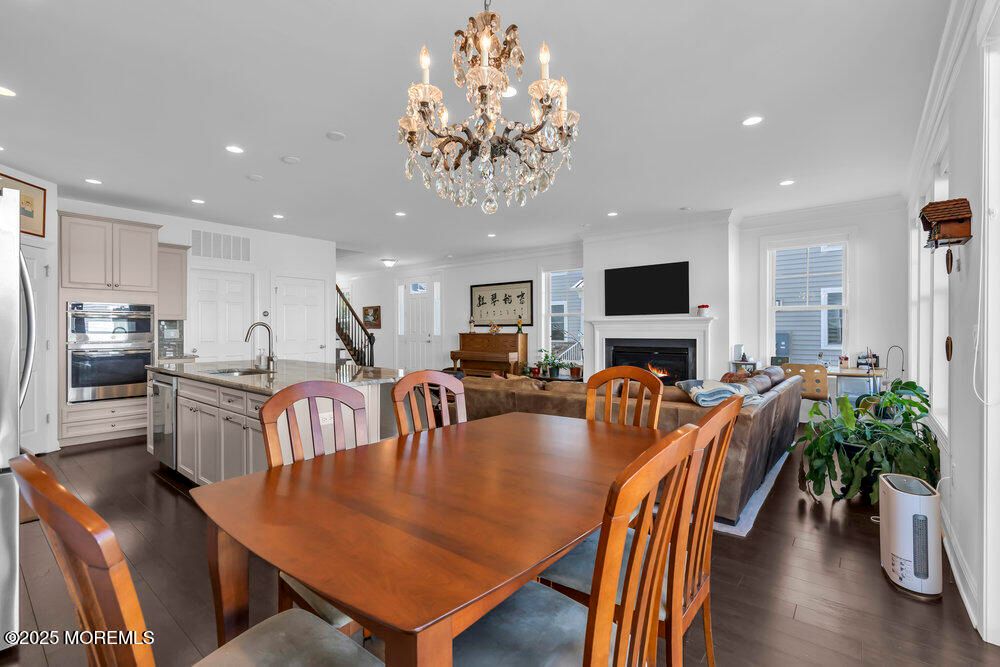 Chandelier, Dining room, Fireplace, Interior, Kitchen, Living room, Recessed Lighting, Stainless Steel Appliances, Wood Texture Flooring