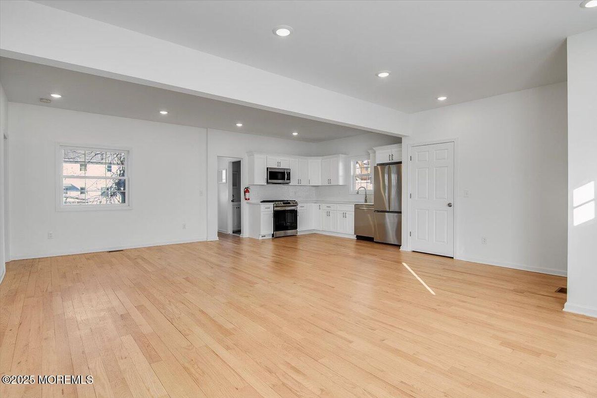 Empty room, Interior, Kitchen, Recessed Lighting, Stainless Steel Appliances, Wood Texture Flooring