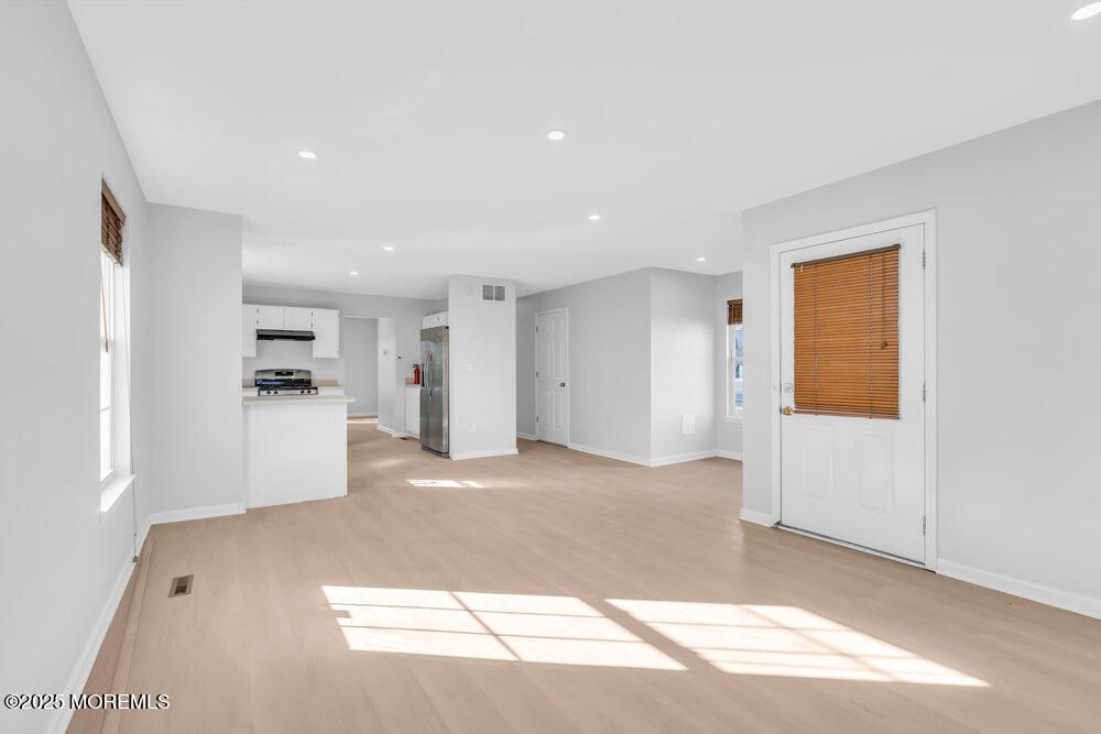 Empty room, Interior, Kitchen, Recessed Lighting, Stainless Steel Appliances, Wood Texture Flooring
