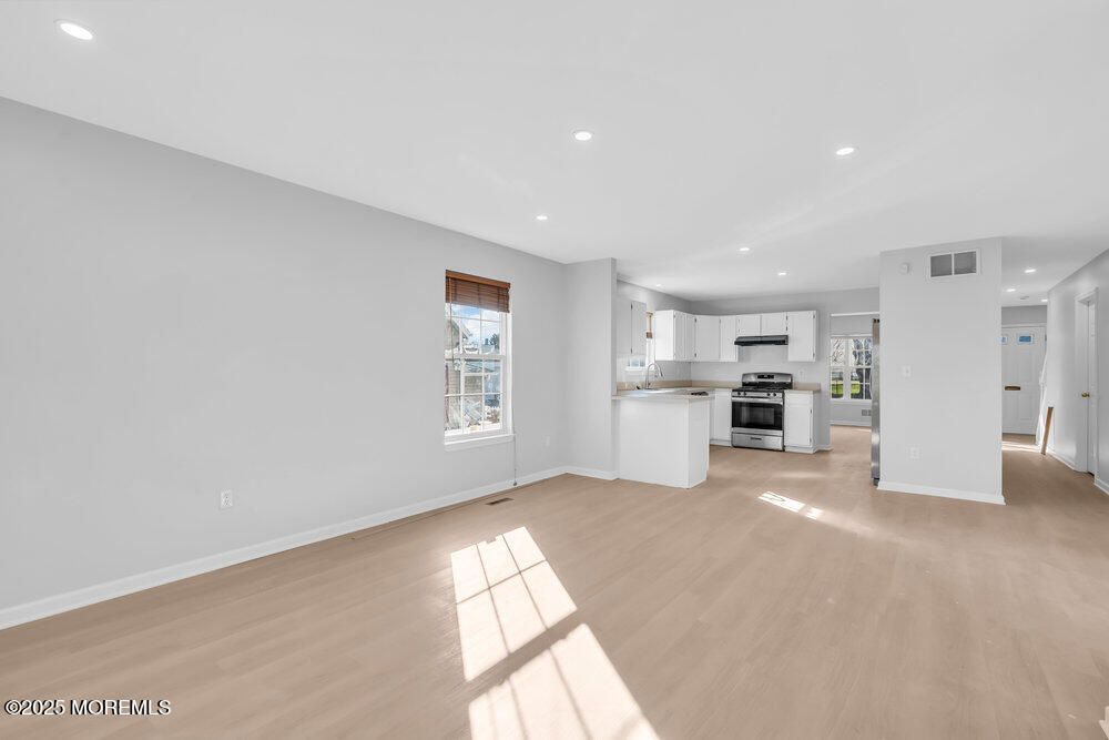 Empty room, Interior, Kitchen, Recessed Lighting, Stainless Steel Appliances, Wood Texture Flooring