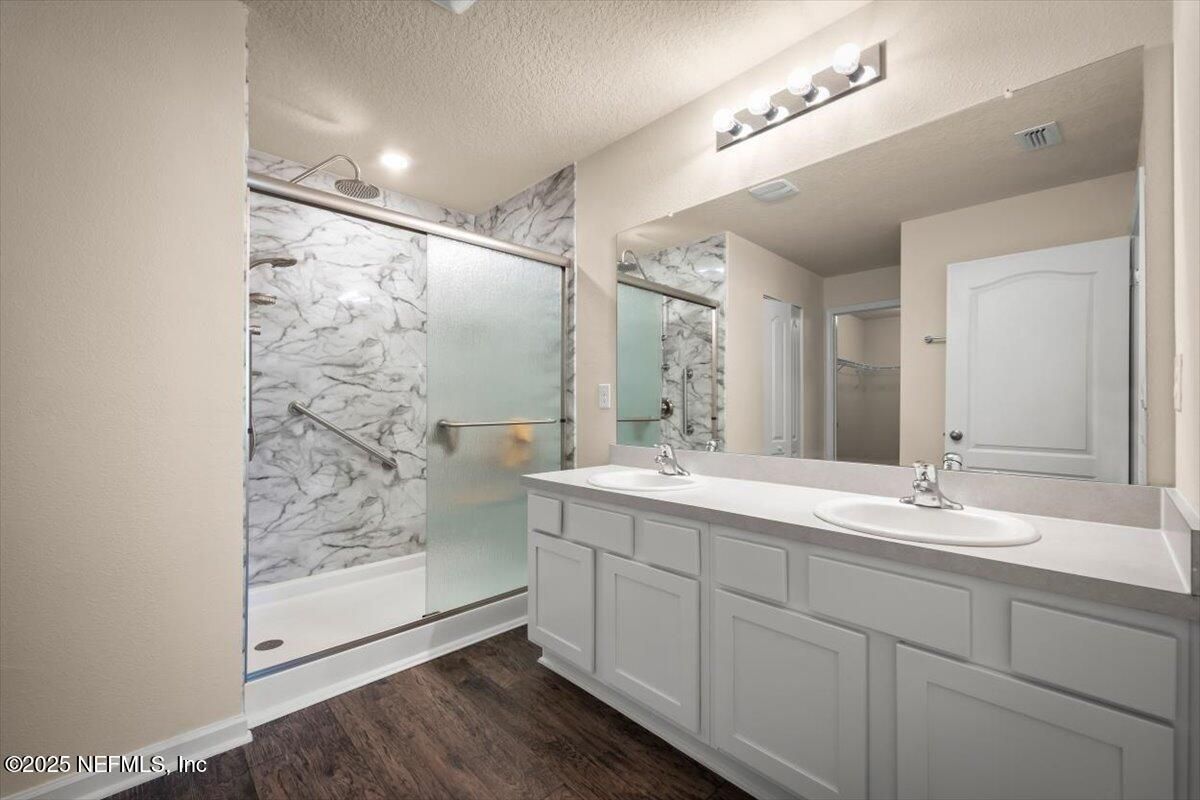 Bathroom, Dual Sink Vanities, Glass Shower, Interior, Marble Walls, Recessed Lighting, Wood Texture Flooring