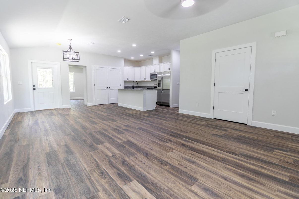 Empty room, Interior, Kitchen, Pendant Lights, Recessed Lighting, Stainless Steel Appliances, Wood Texture Flooring