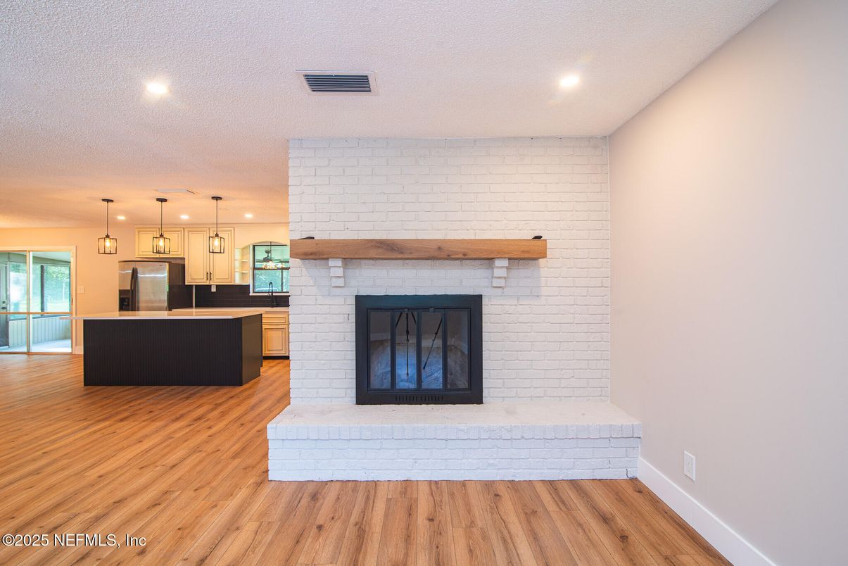 Fireplace, Interior, Kitchen, Pendant Lights, Recessed Lighting, Stainless Steel Appliances, Stone Walls, Wood Texture Flooring