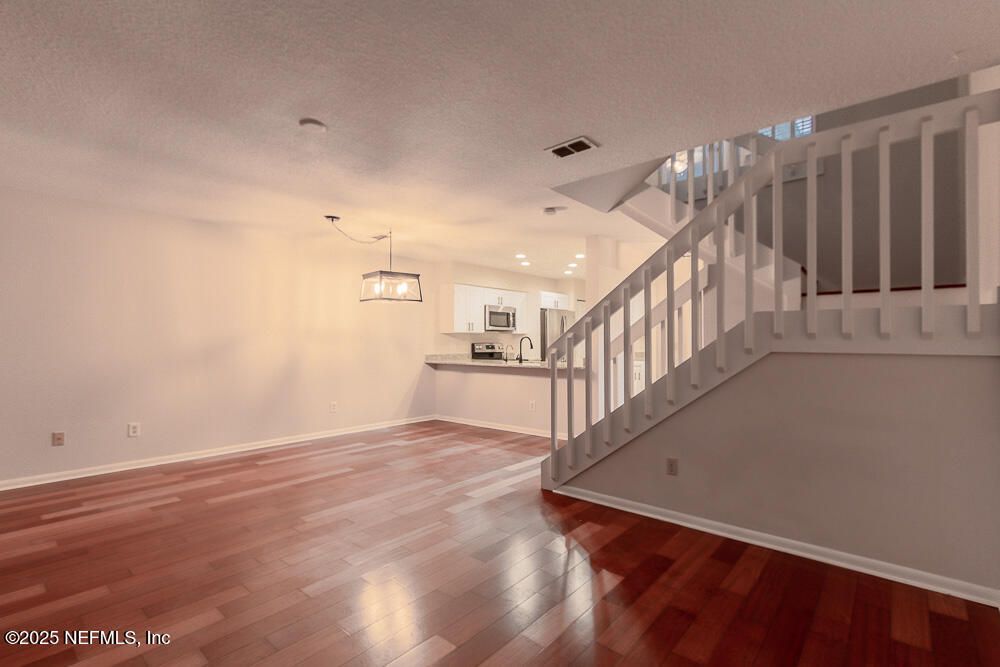 Empty room, Interior, Kitchen, Pendant Lights, Recessed Lighting, Stainless Steel Appliances, Wood Texture Flooring