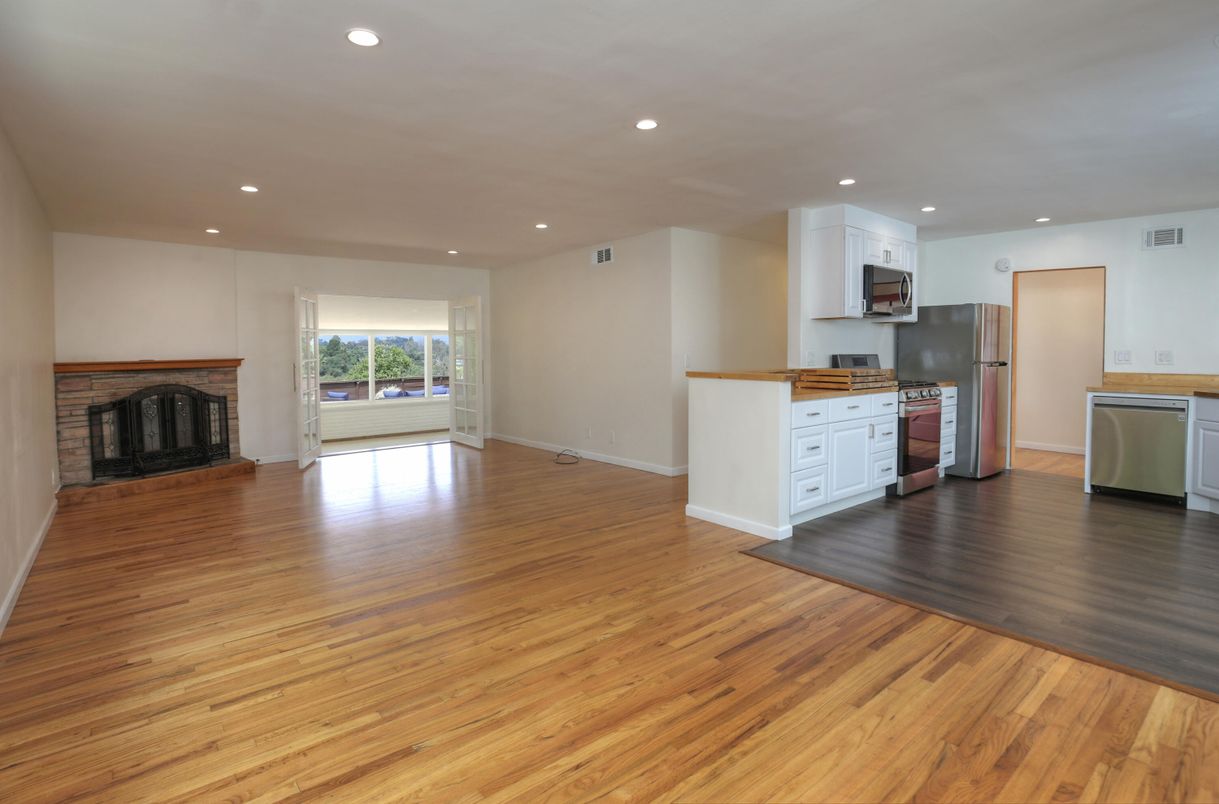 Empty room, Fireplace, Interior, Kitchen, Recessed Lighting, Stainless Steel Appliances, Wood Texture Flooring