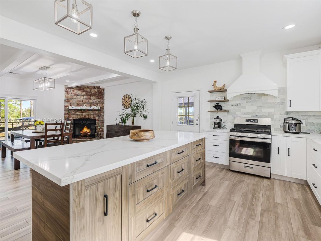 Dining room, Fireplace, Interior, Kitchen, Pendant Lights, Recessed Lighting, Stainless Steel Appliances, Stone Walls, Wood Texture Flooring