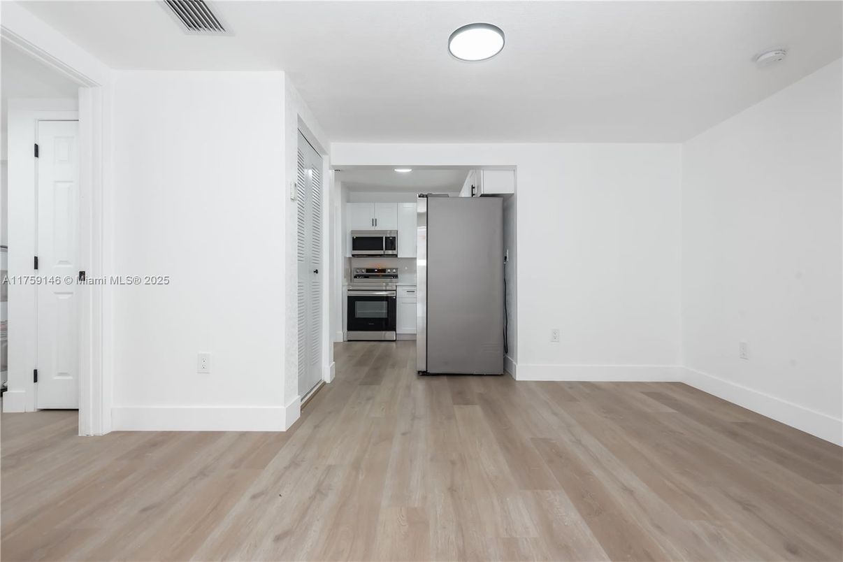 Empty room, Interior, Kitchen, Recessed Lighting, Stainless Steel Appliances, Wood Texture Flooring