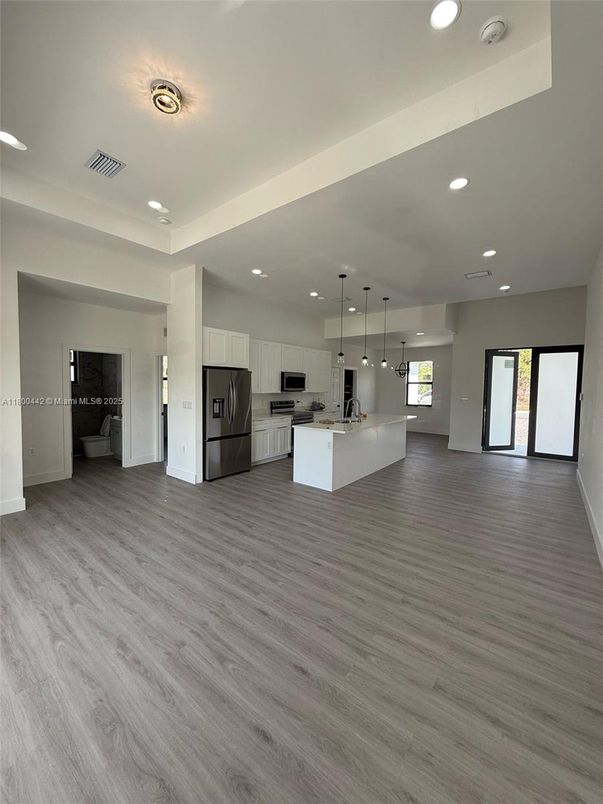 Empty room, Interior, Kitchen, Pendant Lights, Recessed Lighting, Stainless Steel Appliances, Wood Texture Flooring