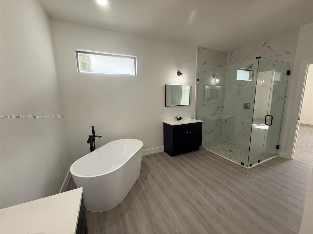 Bathroom, Free Standing Baths, Glass Shower, Interior, Marble Walls, Recessed Lighting, Wood Texture Flooring