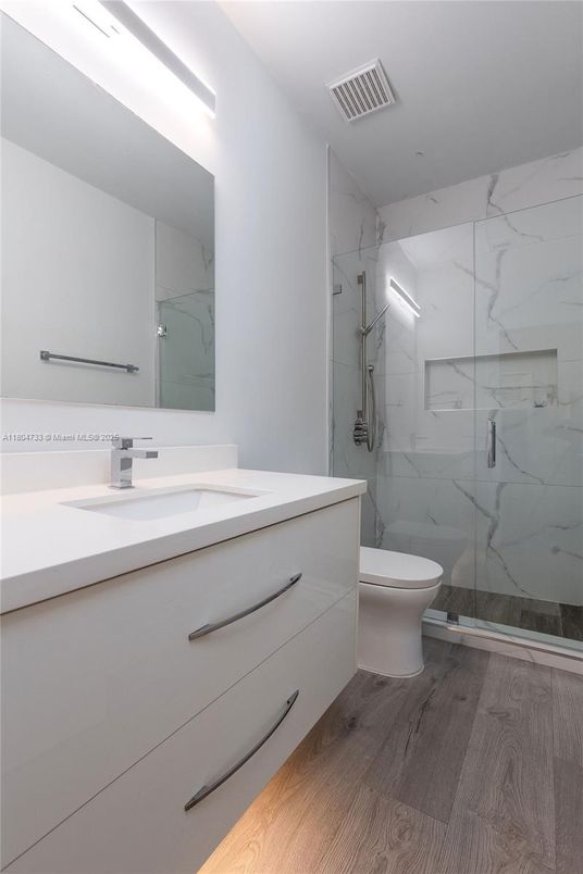 Bathroom, Dual Sink Vanities, Glass Shower, Interior, Marble Walls, Wood Texture Flooring