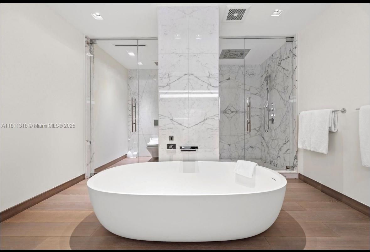 Bathroom, Free Standing Baths, Glass Shower, Interior, Marble Walls, Recessed Lighting, Wood Texture Flooring