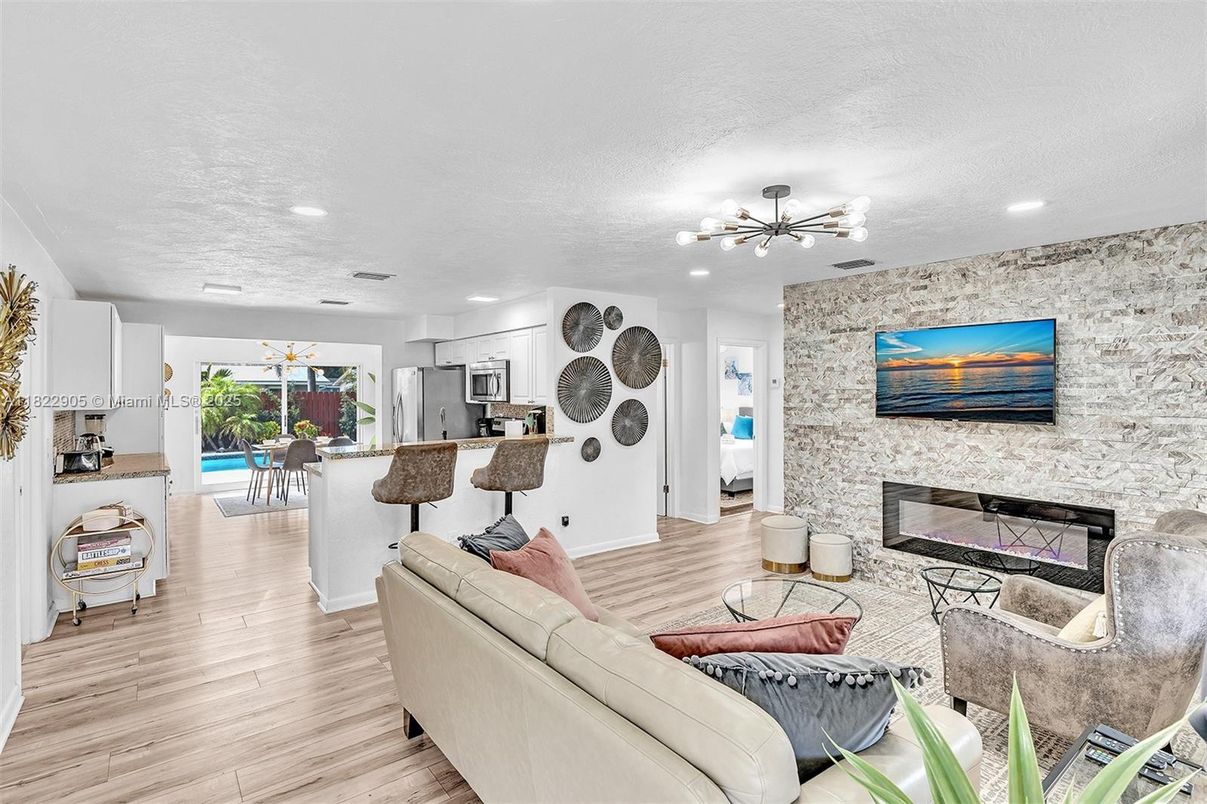Fireplace, Interior, Kitchen, Living room, Pendant Lights, Recessed Lighting, Stainless Steel Appliances, Stone Walls, Wood Texture Flooring