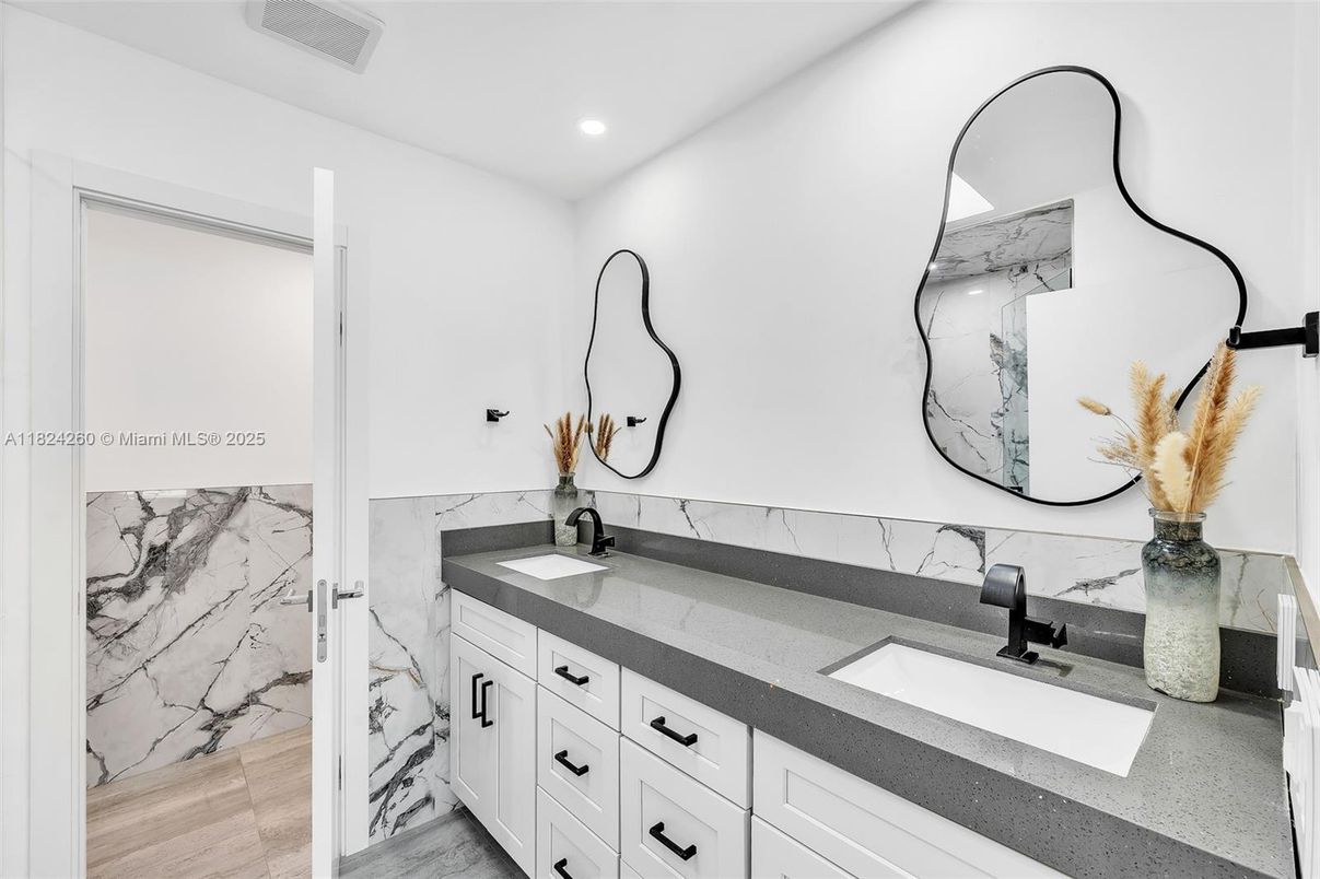 Bathroom, Dual Sink Vanities, Interior, Marble Walls, Recessed Lighting, Wood Texture Flooring
