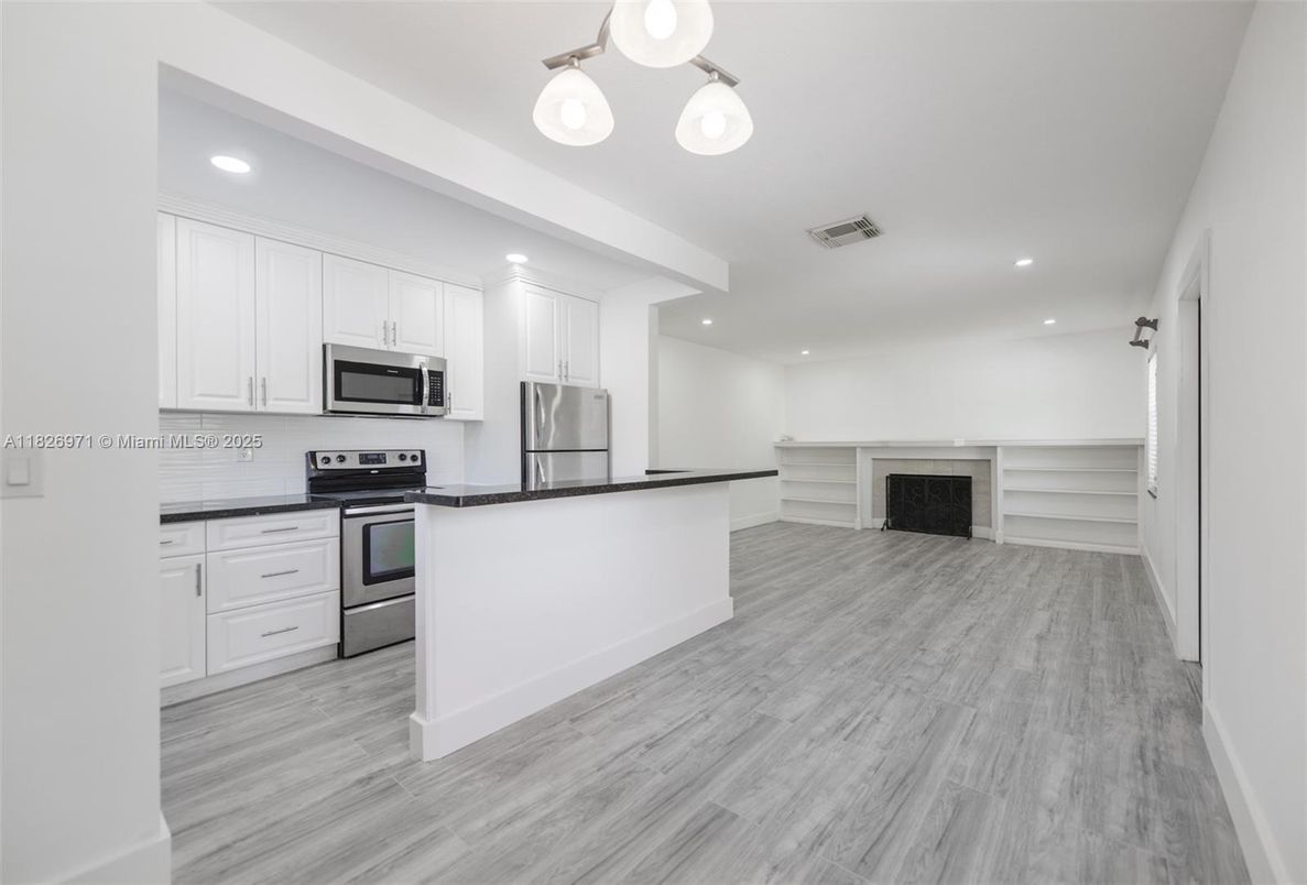 Empty room, Interior, Kitchen, Recessed Lighting, Stainless Steel Appliances, Wood Texture Flooring