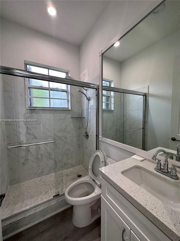 Bathroom, Dual Sink Vanities, Glass Shower, Interior, Marble Walls, Recessed Lighting, Wood Texture Flooring