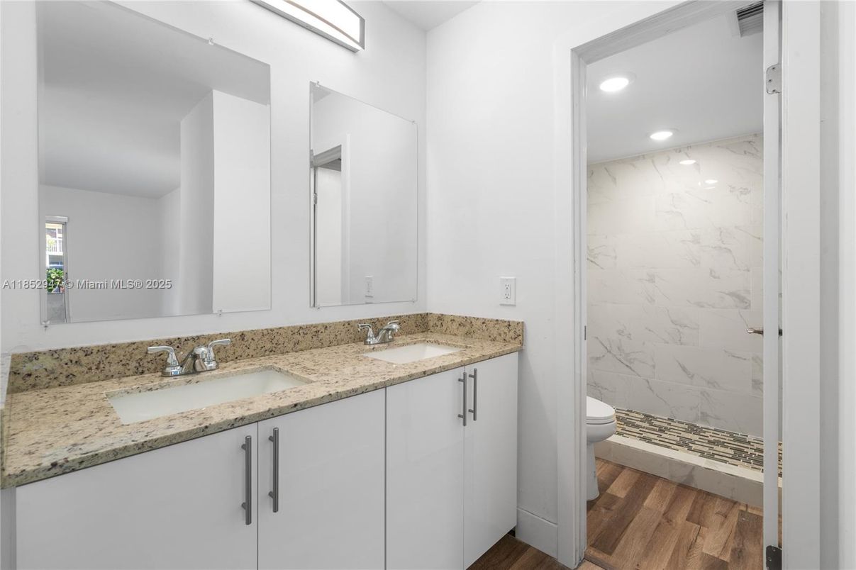Bathroom, Dual Sink Vanities, Interior, Marble Walls, Recessed Lighting, Wood Texture Flooring
