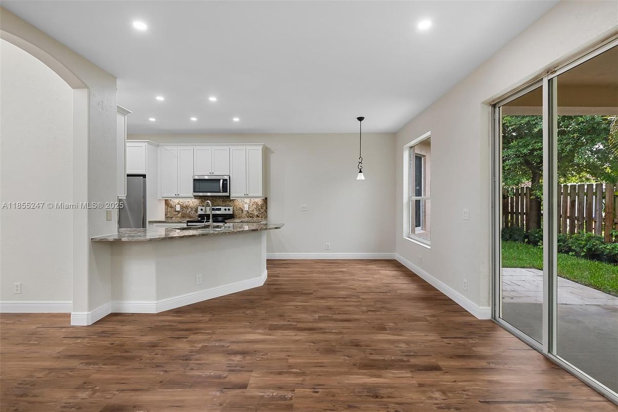 Empty room, Interior, Kitchen, Pendant Lights, Recessed Lighting, Stainless Steel Appliances, Wood Texture Flooring