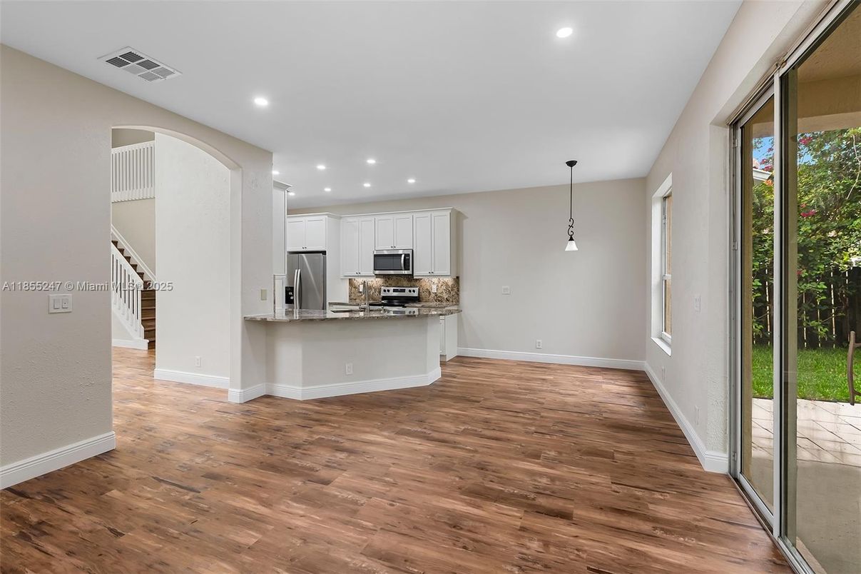 Empty room, Interior, Kitchen, Pendant Lights, Recessed Lighting, Stainless Steel Appliances, Wood Texture Flooring