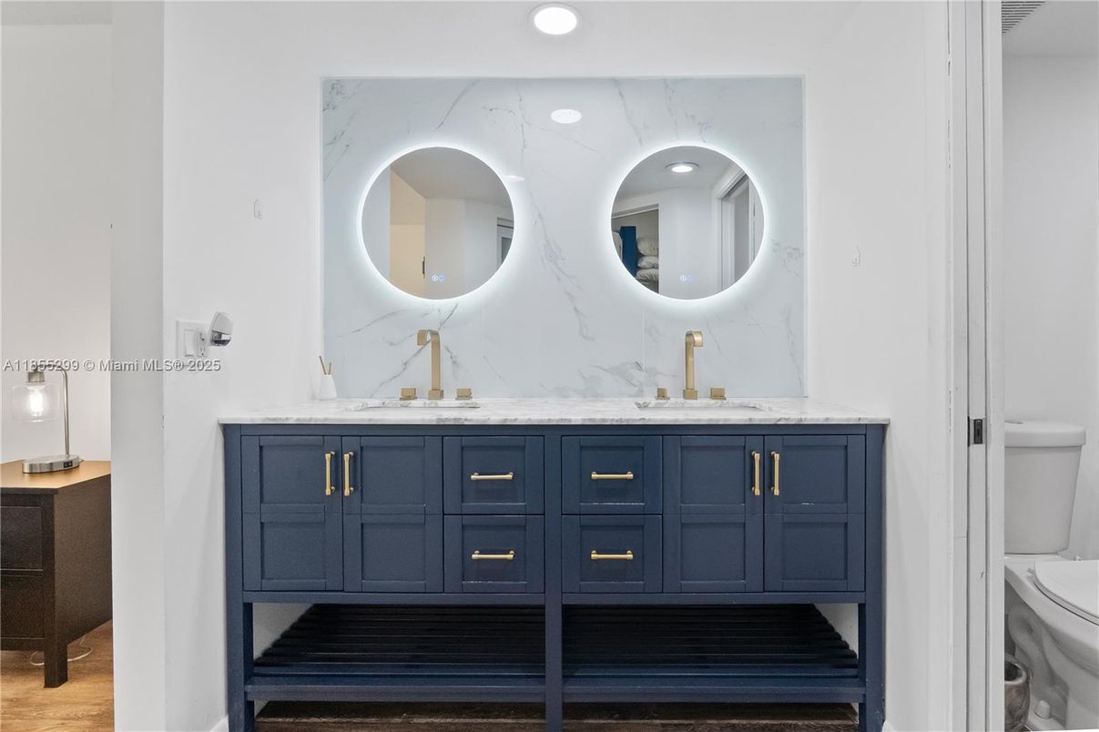 Bathroom, Dual Sink Vanities, Interior, Marble Walls, Recessed Lighting, Wood Texture Flooring