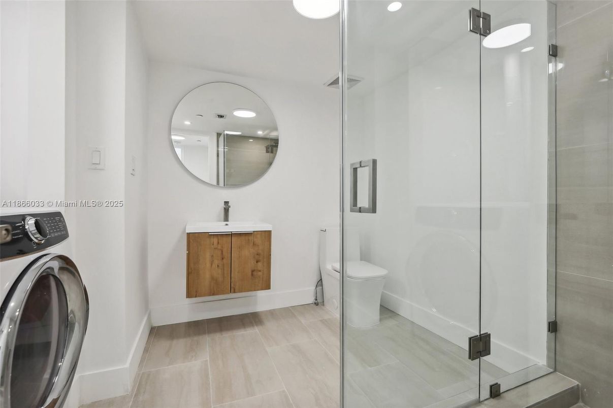 Bathroom, Glass Shower, Interior, Recessed Lighting, Washer, Wood Texture Flooring