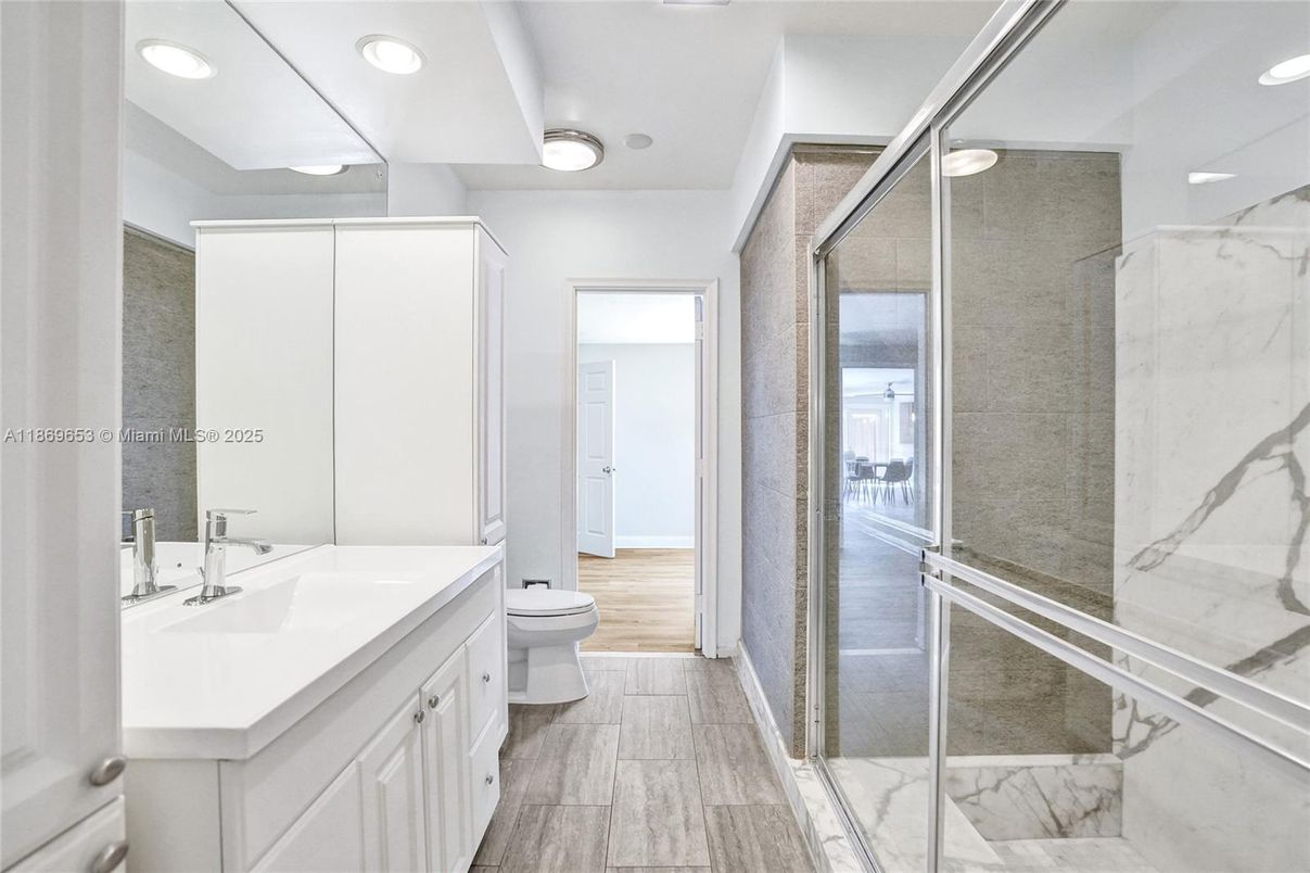 Bathroom, Dual Sink Vanities, Glass Shower, Interior, Marble Walls, Recessed Lighting, Wood Texture Flooring