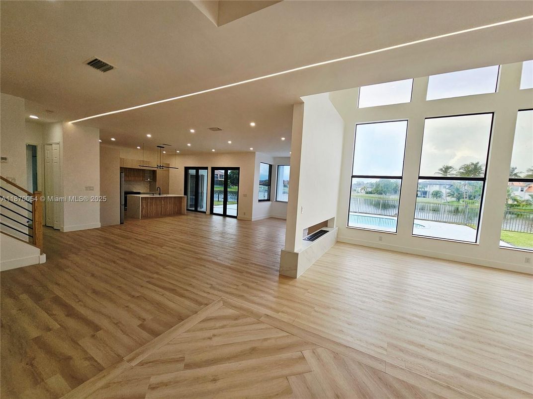 Empty room, Fireplace, Interior, Kitchen, Pendant Lights, Recessed Lighting, Stainless Steel Appliances, Wood Texture Flooring